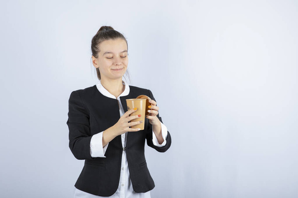 Portré gyönyörű nő csésze kávé áll a fehér háttér. Kiváló minőségű fénykép - Fotó, kép