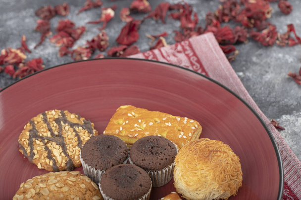 Snack dolci con petali secchi posti su un tavolo di pietra. Foto di alta qualità - Foto, immagini