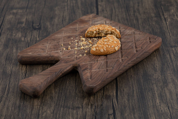 Зламане смачне печиво з зернами, розміщеними на дерев'яній обробній дошці. Високоякісна фотографія
 - Фото, зображення