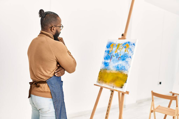 Jeune artiste afro-américain sur la vue de dos regardant le dessin au studio d'art. - Photo, image