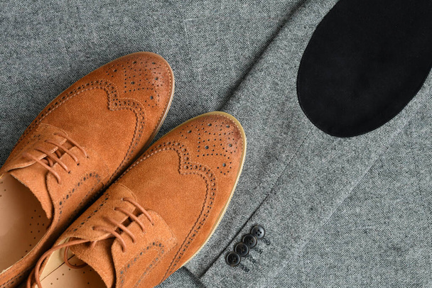 Une paire de chaussures derby en daim marron sur fond de tissu tweed. Concentration sélective. - Photo, image
