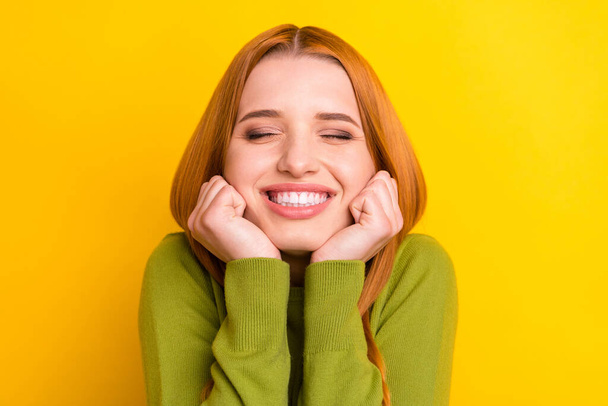 Photo of cute orange hair millennial lady hands chin wear green sweater isolated on yellow color background - Foto, Imagem