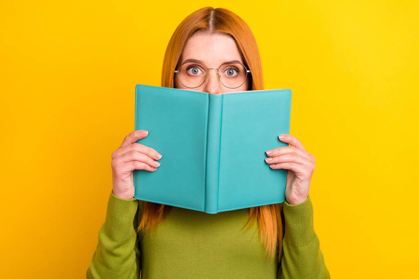 Photo of stressed red hair young lady hold book wear eyewear green sweater isolated on yellow color background - Foto, immagini