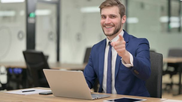 Businessman with Laptop Pointing at Camera  - Photo, image