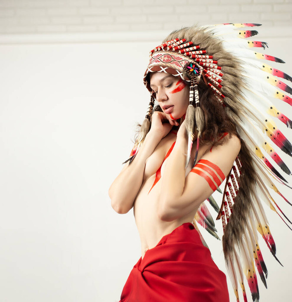 naked woman in native american costume with feathers - Foto, afbeelding