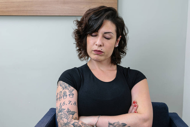 Бразильская женщина с татуировкой, со скрещенными руками и закрытыми глазами. Расстроен и зол. - Фото, изображение