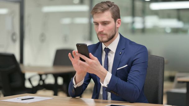 Geschäftsmann nutzt Smartphone bei der Arbeit  - Foto, Bild