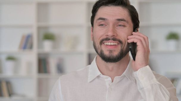 fröhlicher junger Mann telefoniert  - Foto, Bild