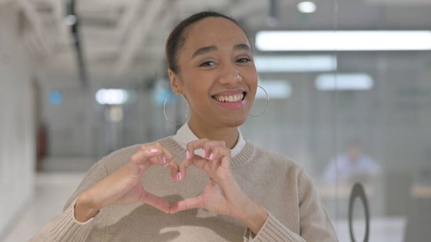 Afrikanerin zeigt Herzform an den Händen  - Foto, Bild