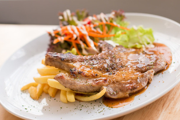 Свиной стейк и картофель фри с соусом
 - Фото, изображение