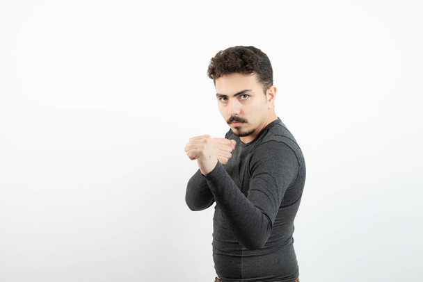 Portrait photo of a young sporty man standing and giving punch . High quality photo - Fotó, kép