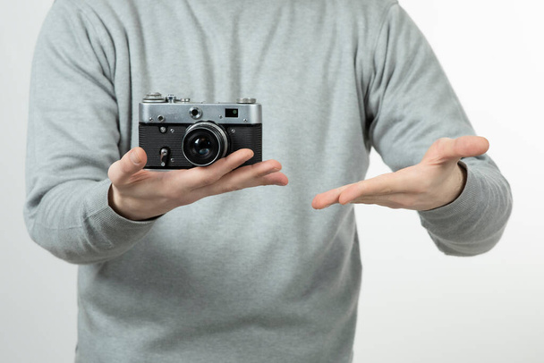 Мужчина, профессиональный фотограф, держит ретро-камеру. Высокое качество фото - Фото, изображение