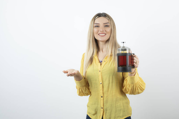 Retrato de una joven rubia sosteniendo una tetera caliente. Foto de alta calidad - Foto, Imagen