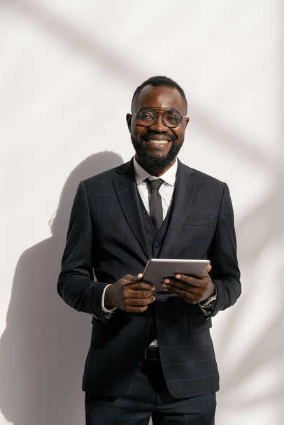 Úspěšný obchodník v elegantním obleku se na vás dívá s úsměvem - Fotografie, Obrázek