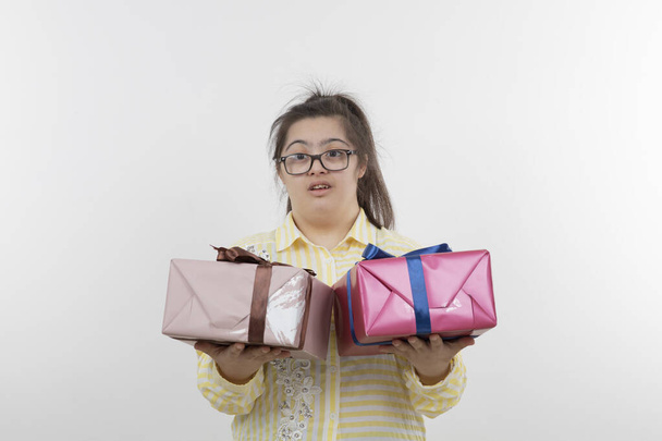 menina com síndrome de down posando com caixas de presente - Foto, Imagem