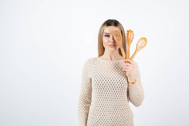 Fotografie atraktivní mladé ženy stojící a držící kuchyňské nářadí. Kvalitní fotografie - Fotografie, Obrázek