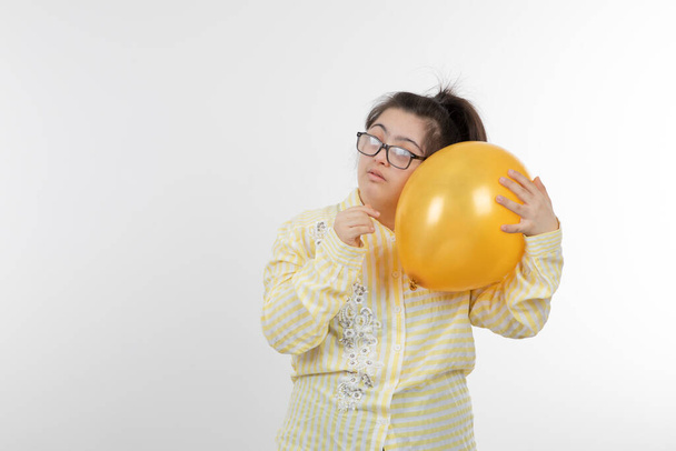 dziewczyna z zespołem Downa pozowanie z balonem - Zdjęcie, obraz