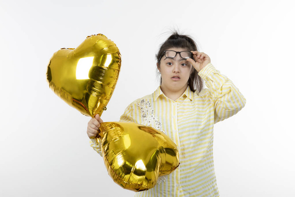 dziewczyna z zespołem Downa pozowanie ze złotym sercem balony - Zdjęcie, obraz