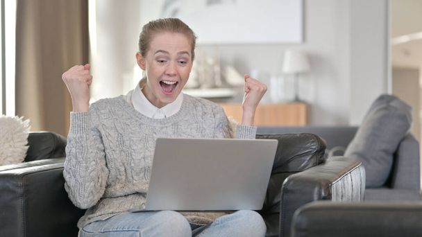 Donna di successo che festeggia sul computer portatile a casa
 - Foto, immagini