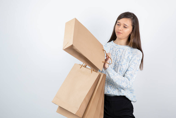 Retrato de adolescente en suéter sosteniendo bolsas de compras - Foto, Imagen