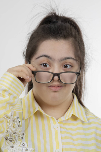 Porträt eines Mädchens mit Down-Syndrom mit lustigem Gesichtsausdruck - Foto, Bild