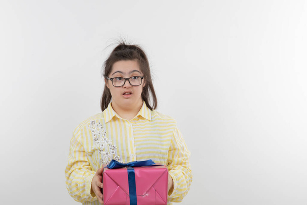 Mädchen mit Down-Syndrom posiert mit Geschenkschachtel - Foto, Bild