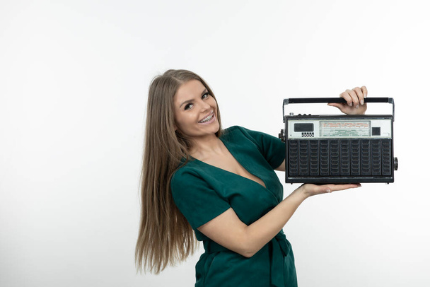 Beeld van mooie vrouw met draagbare radio ontvanger poseren voor camera. Hoge kwaliteit foto - Foto, afbeelding