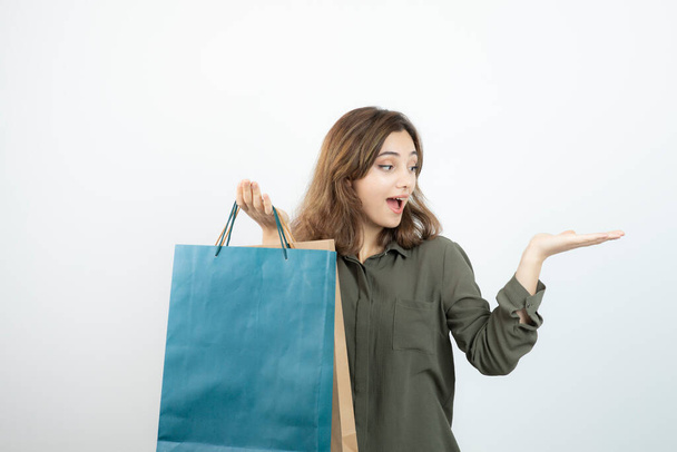 Image of beautiful short-haired girl with shopping bags standing. High quality photo - Foto, Imagen