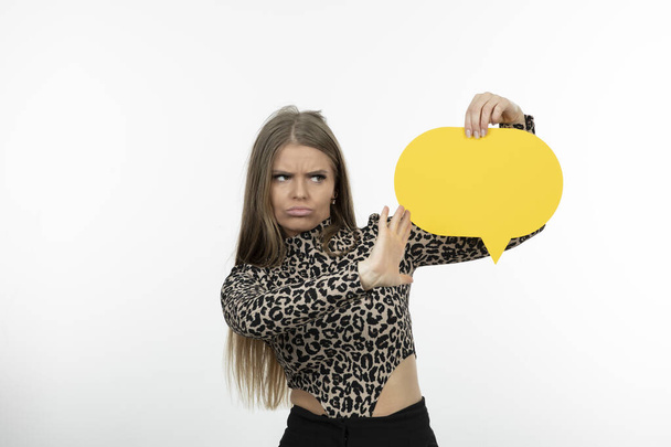 Portrait of a nice-looking woman model holding yellow speech bubble . High quality photo - Photo, Image