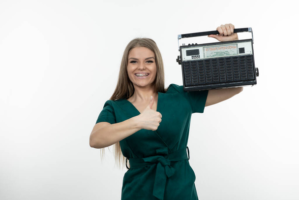Beeld van een mooie vrouw met draagbare radio ontvanger die duimen opgeeft. Hoge kwaliteit foto - Foto, afbeelding