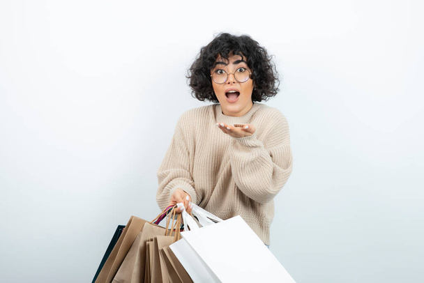 Happy female shopper carrying shopping bags over white. High quality photo - Photo, Image