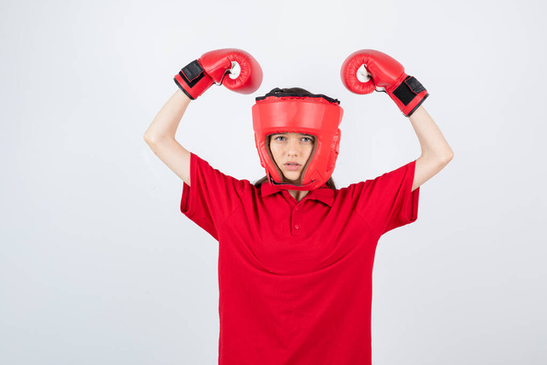menina em camiseta vermelha com luvas de boxe e máscara protetora - Foto, Imagem