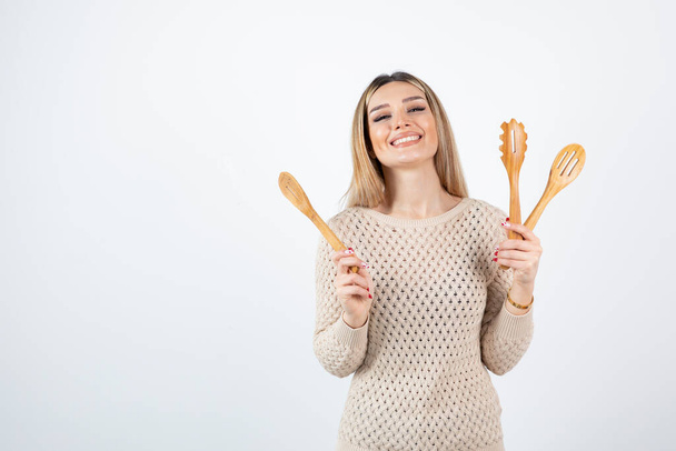 Fotografie atraktivní mladé ženy stojící a držící kuchyňské nářadí. Kvalitní fotografie - Fotografie, Obrázek