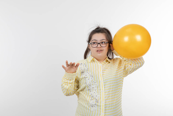 chica con síndrome de Down posando con globo - Foto, imagen