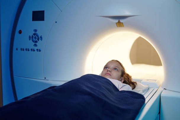 Schattig kind dat in MRI-scan machine stapt voor het onderzoek - Foto, afbeelding