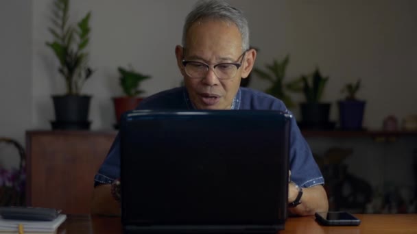 Starszy dyrektor biznesowy nosi okulary, rozmawia z pracownikiem firmy z wideokonferencją na laptopie w domu. Komunikacja na odległość przez internetową kamerę internetową. Praca w domu. - Materiał filmowy, wideo
