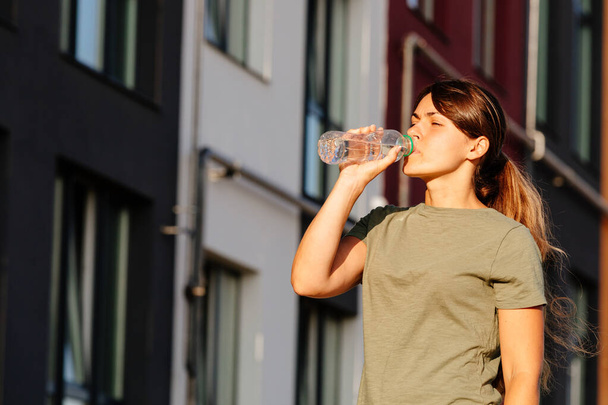 a girl drinks water after sport. healthy active lifestyle - Foto, Imagem