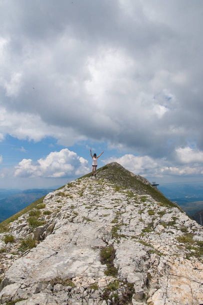 MONTE BOVE SUD, ITALY - JULY 12, 2021: Portrait of happy woman in the summit of Monte Bove in the national park of Monti Sibillini, Marche, Italy - 写真・画像
