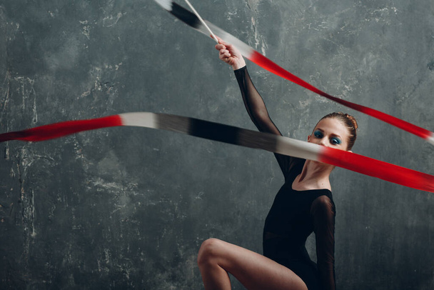 Jovem mulher ginasta profissional ginástica rítmica com fita no estúdio - Foto, Imagem