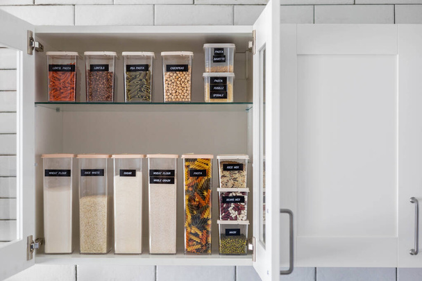 Kitchen storage organization use plastic case. Placing and sorting food products into pp box - Фото, изображение