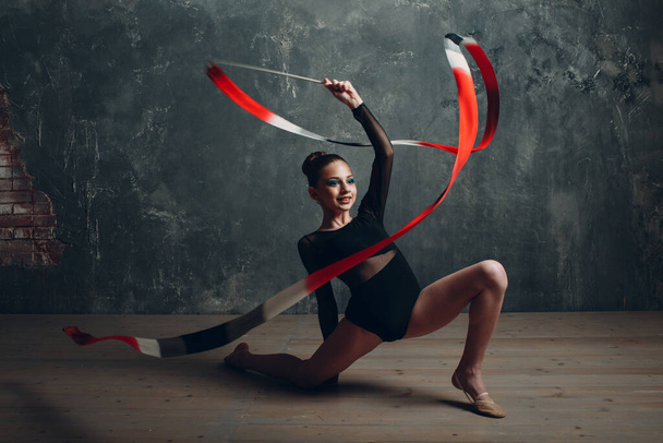 Chica joven gimnasta profesional mujer gimnasia rítmica con cinta en el estudio - Foto, Imagen