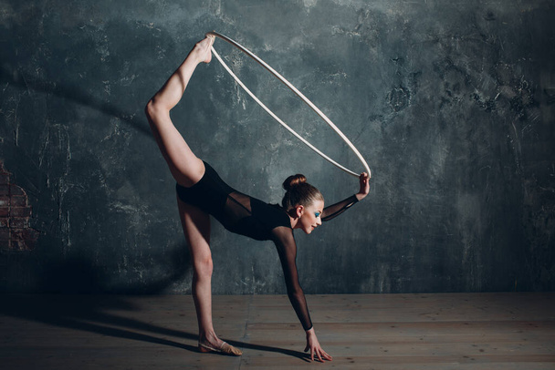 Fiatal lány szakmai tornász nő tánc ritmikus torna karika a stúdióban - Fotó, kép