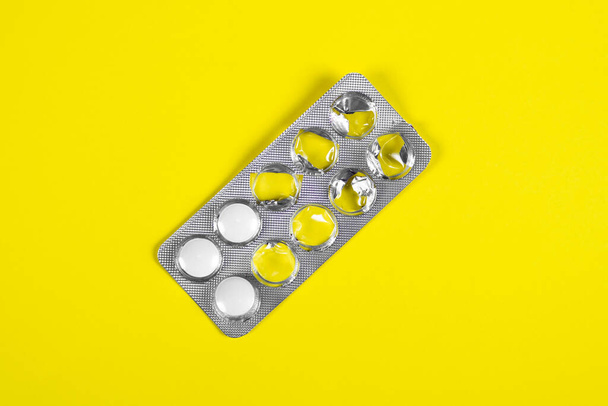 Pills Pack on the Yellow Paper Background closeup - Foto, afbeelding
