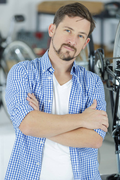 friendly and competent bicycle mechanic in a workshop posing - Foto, immagini
