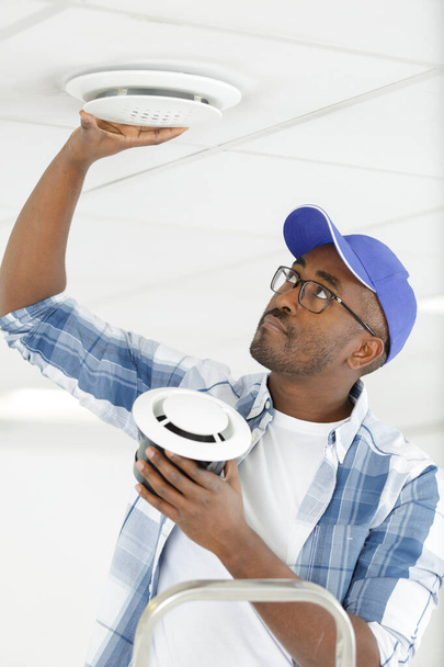 worker repairing ceiling air conditioning unit - Фото, изображение