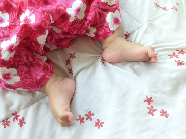 Uyku tulumunda uyuyan bebek ayaklarının üst görüntüsü, yavaşça ilginç görüntüye odaklan. - Fotoğraf, Görsel