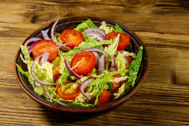 Healthy salad with savoy cabbage, cherry tomato, red onion and olive oil on wooden table - Photo, image