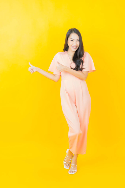 Portrait beautiful young asian woman smile with action on color background - Foto, Imagem