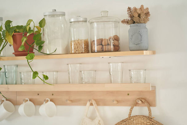 A set of glass jars with bulk products on the kitchen shelf. Pasta, sugar. Beautiful kitchen decor. - Fotografie, Obrázek