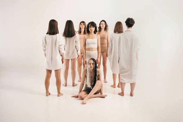Girls with different types of figures stand. Study of female psychology. Connection between people. The ability of people to be themselves in society. Girls are ashamed of their figures - Photo, Image